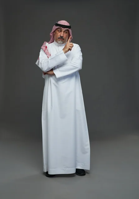 رجل سعودي بالزي التقليدي والشماغ في وضعية تفكير