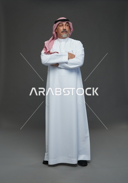 رجل سعودي بالزي التقليدي يقف في الاستوديو