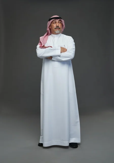 رجل سعودي بالزي التقليدي يقف في الاستوديو