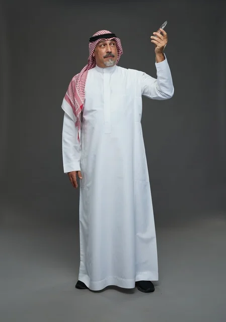 Saudi Man in Traditional Dress on Gray Background
