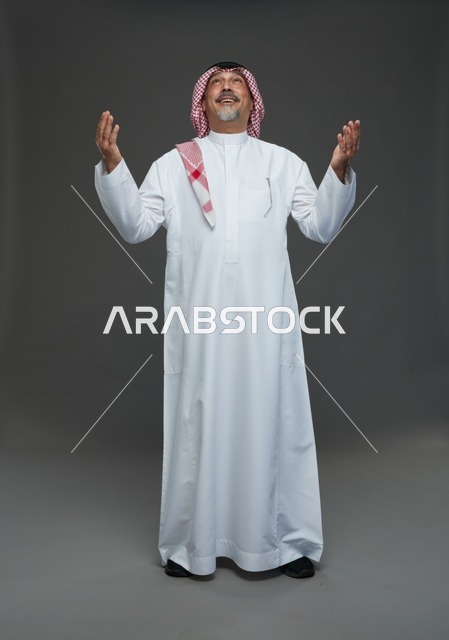 Saudi Man in Traditional Dress Praying in Gray Studio