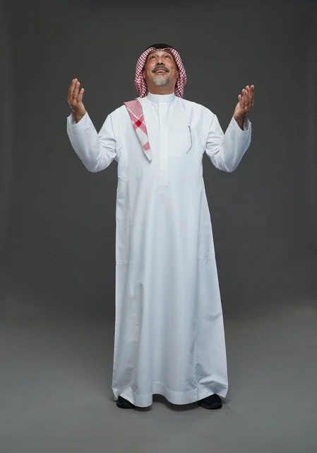 Saudi Man in Traditional Dress Praying in Gray Studio