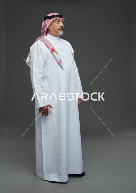 بورتريه رجل سعودي بالثوب والشماغ خلفية استوديو رمادية