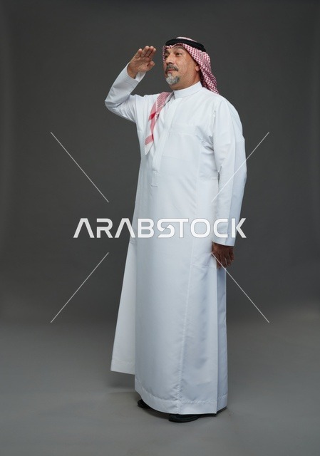 رجل سعودي بالزي التقليدي يؤدي التحية العسكرية