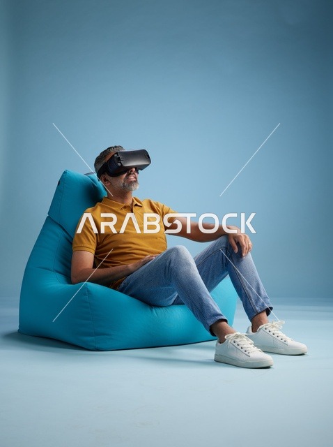 Saudi Man using VR Headset on Blue Bean Bag Chair