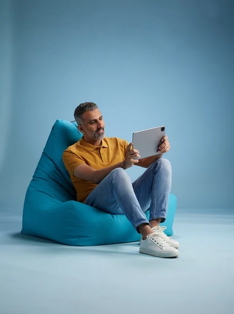 Saudi Man Sitting on Bean Bag Using Digital Tablet
