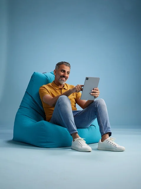 Saudi Man Using Digital Tablet on Blue Bean Bag
