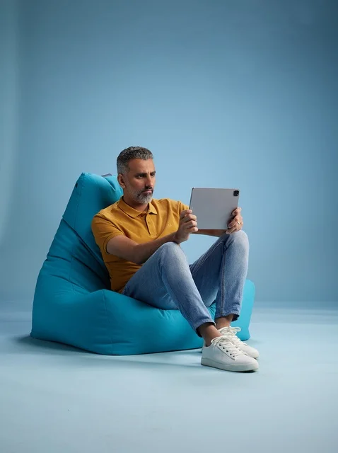 Saudi Man Using Digital Tablet on Bean Bag in Studio
