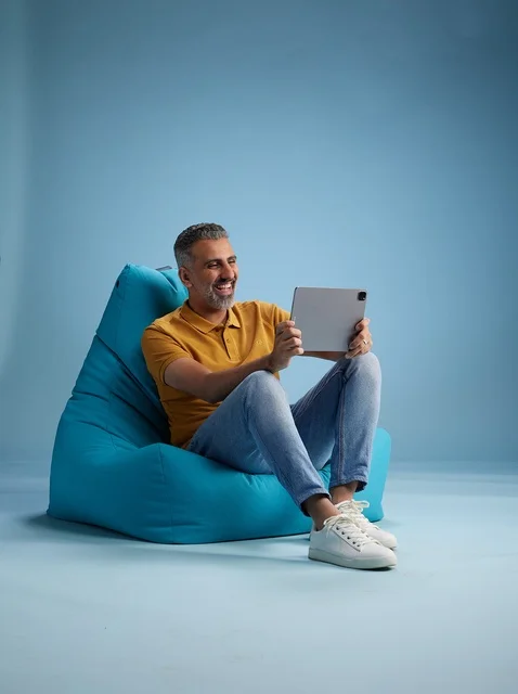 رجل سعودي يستخدم جهاز لوحي على كرسي بين باج