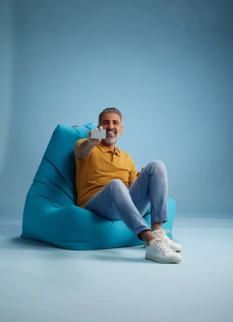 Saudi Man on Bean Bag Holding Credit Card