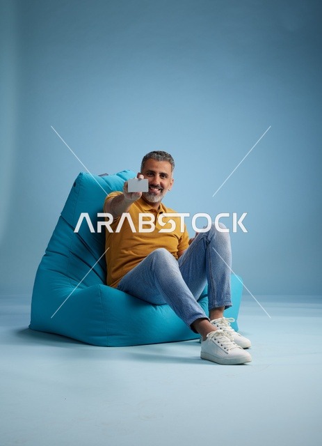 Saudi Man Holding Credit Card on Bean Bag Chair