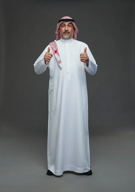رجل سعودي بالزي التقليدي يشير بعلامة الإعجاب