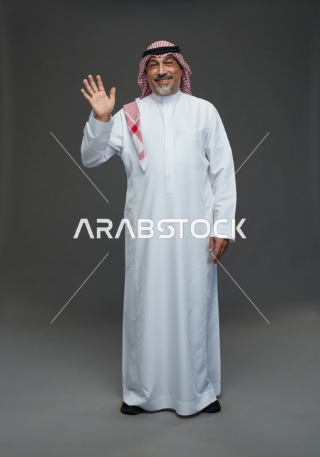 رجل سعودي بالزي التقليدي يلوح بيده في الاستوديو