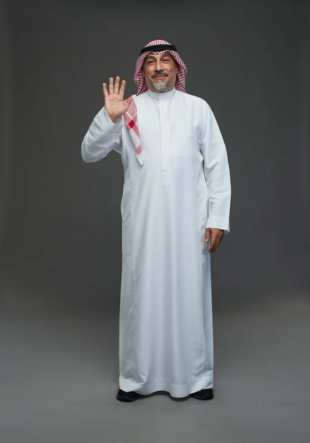 Saudi Man in Traditional Dress Waving on Gray Background