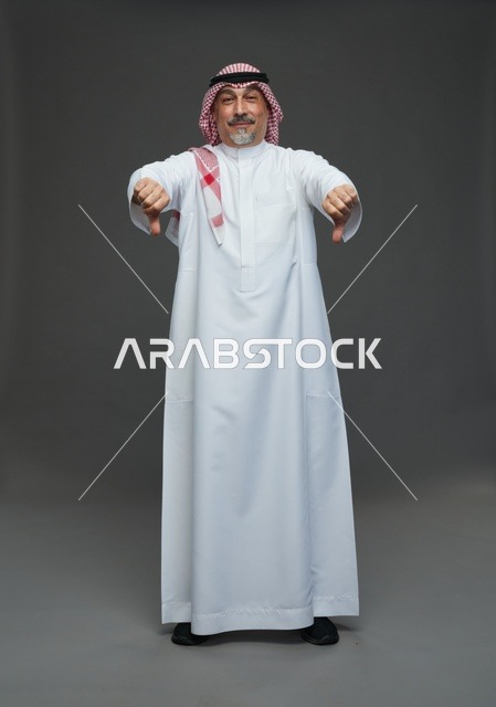 رجل سعودي بالزي التقليدي يشير بالإبهام للأسفل