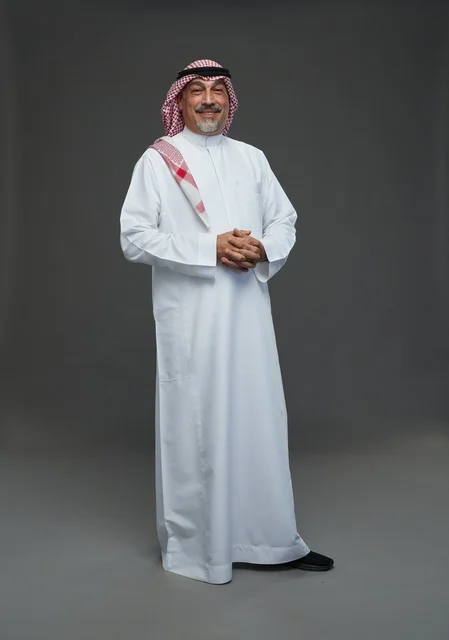 رجل سعودي بالثوب والشماغ التقليدي خلفية رمادية