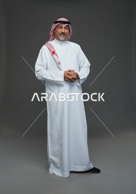 رجل سعودي بالزي التقليدي السعودي على خلفية رمادية سادة