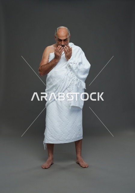رجل سعودي بملابس الإحرام يدعو أثناء المناسك