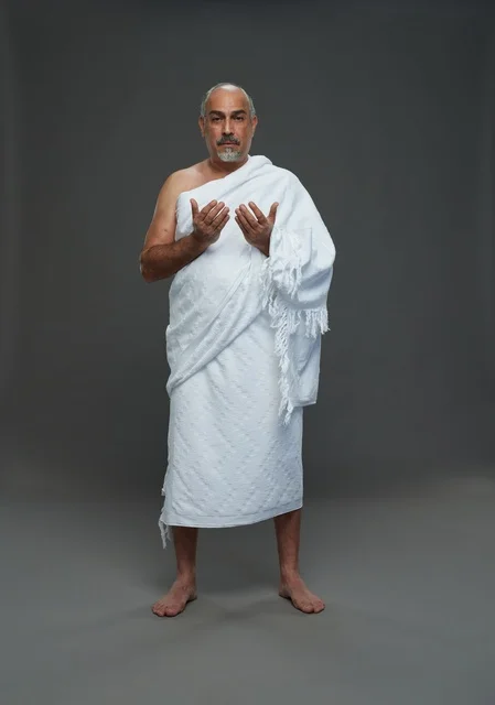 رجل سعودي بملابس الإحرام يدعو في الاستوديو