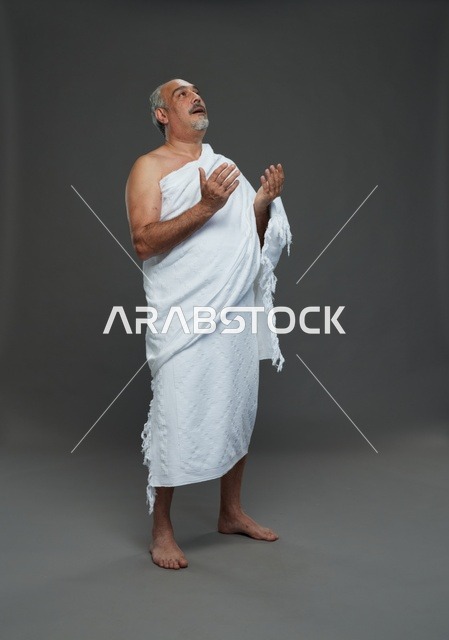 رجل سعودي بملابس الإحرام يدعو في الاستوديو