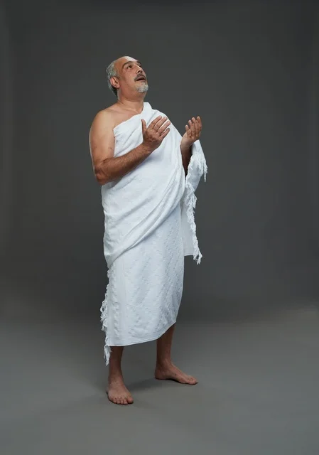 رجل سعودي بملابس الإحرام يدعو في الاستوديو