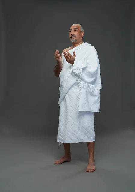 رجل سعودي بملابس الإحرام يدعو أثناء أداء المناسك