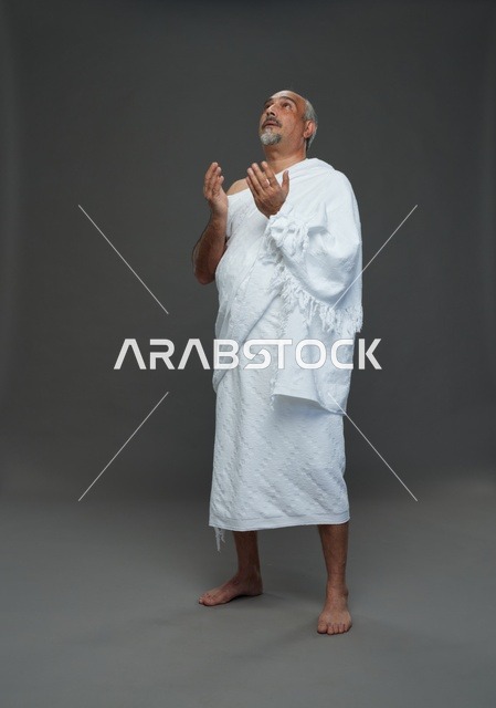 رجل سعودي بملابس الإحرام يدعو في الاستوديو