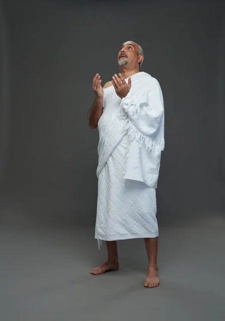 رجل سعودي بملابس الإحرام يدعو في الاستوديو