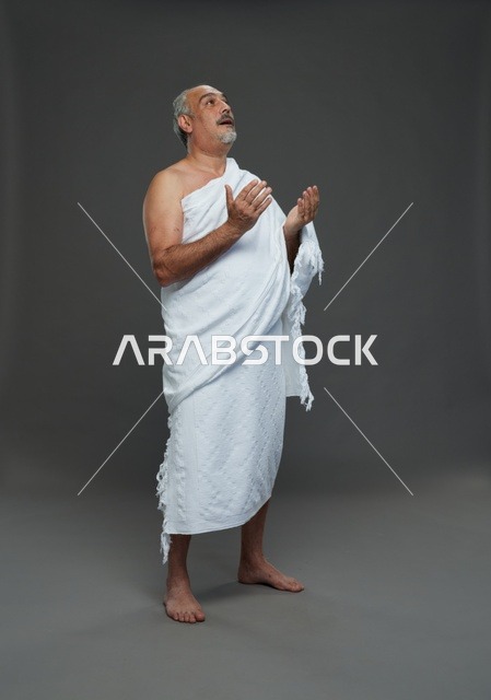 رجل سعودي بملابس الإحرام البيضاء يدعو أثناء أداء المناسك