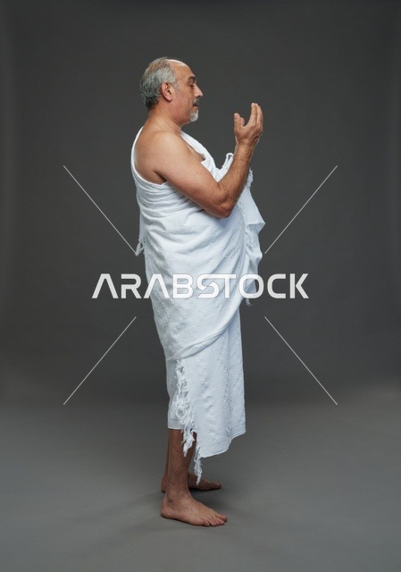 رجل سعودي بملابس الإحرام يدعو أثناء أداء مناسك الحج