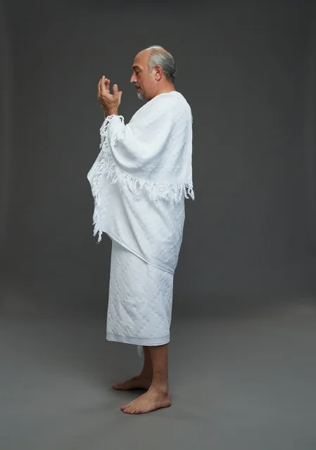 Saudi Man in Ihram Praying on Gray Background