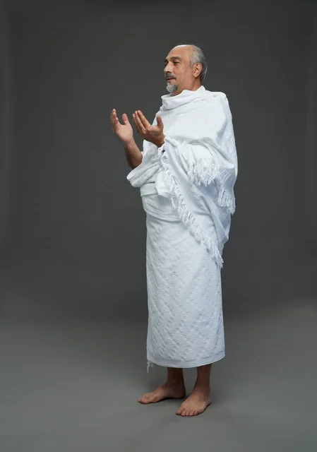 رجل سعودي بملابس الإحرام يدعو أثناء أداء المناسك