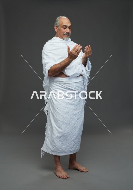 رجل سعودي بملابس الإحرام يدعو في الاستوديو