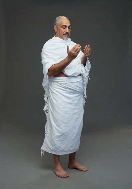 رجل سعودي بملابس الإحرام يدعو في الاستوديو