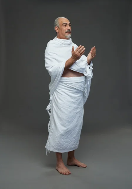 رجل سعودي بملابس الإحرام يدعو في الاستوديو