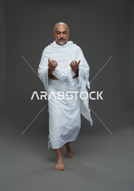 رجل سعودي بملابس الإحرام يدعو في الاستوديو