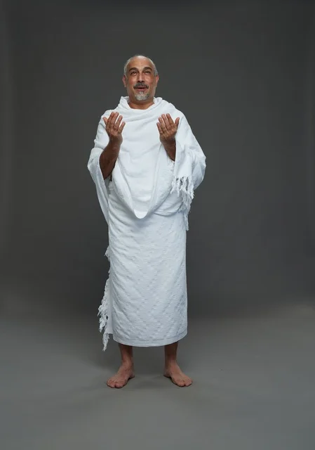 رجل سعودي بملابس الإحرام يدعو أثناء أداء المناسك