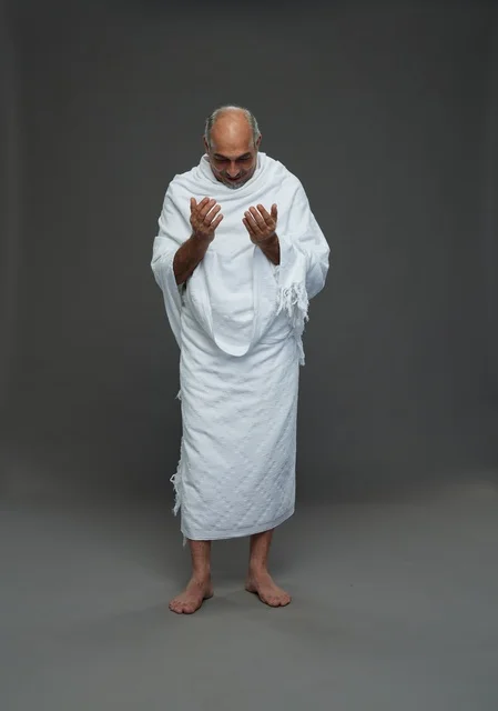 Saudi man in Ihram clothing praying during pilgrimage