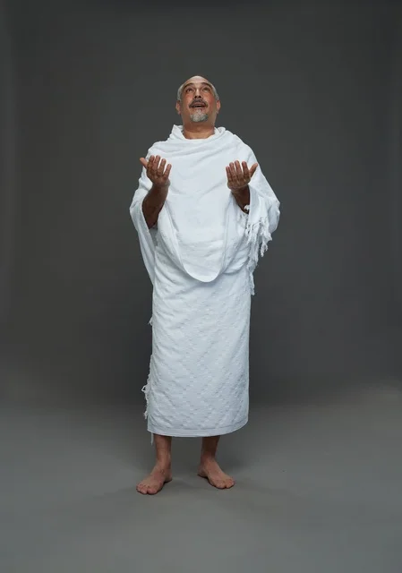 رجل سعودي بملابس الإحرام يدعو في الاستوديو