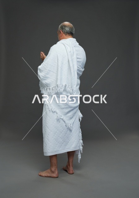 رجل سعودي بملابس الإحرام يدعو من الخلف