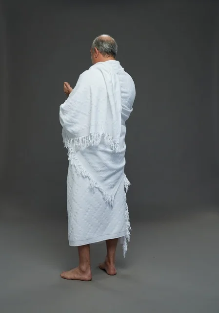 Saudi Man in Ihram Clothing Praying Rear View