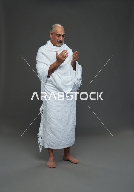 رجل سعودي بملابس الإحرام يدعو في الاستوديو