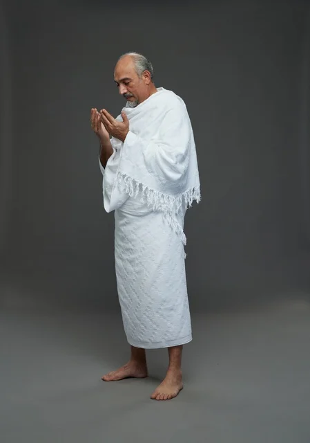 رجل سعودي بملابس الإحرام يدعو في الاستوديو