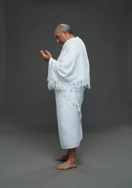 رجل سعودي بملابس الإحرام يدعو في الاستوديو