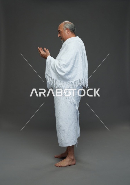 رجل سعودي بملابس الإحرام يدعو أثناء المناسك