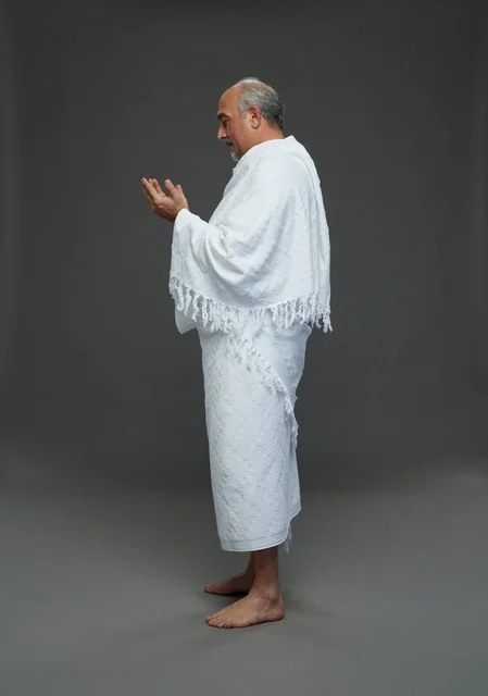 رجل سعودي بملابس الإحرام يدعو أثناء المناسك