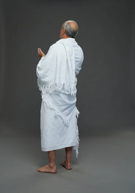 رجل سعودي بملابس الإحرام يدعو أثناء أداء مناسك الحج