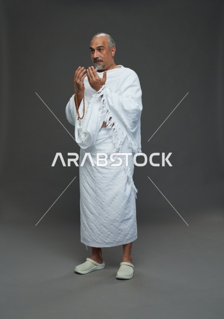 رجل سعودي بملابس الإحرام يدعو أثناء أداء المناسك