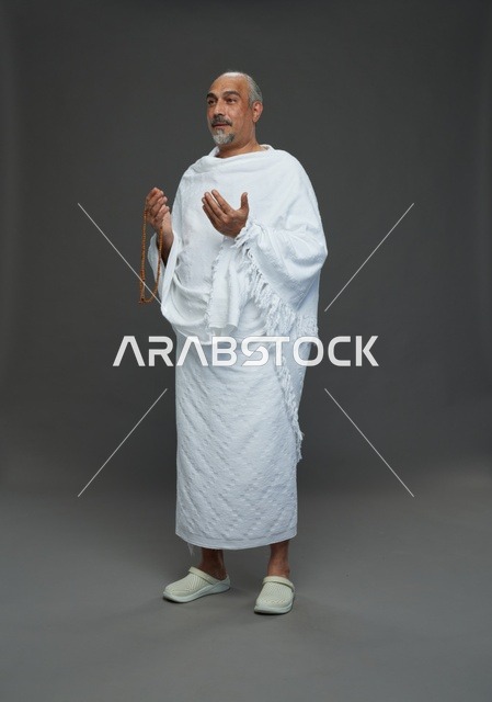رجل سعودي بملابس الإحرام يدعو أثناء الحج والعمرة