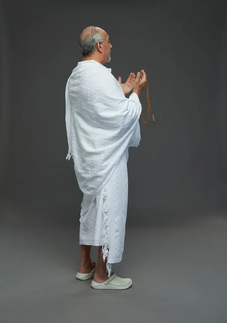 رجل سعودي بملابس الإحرام يدعو بالمسبحة